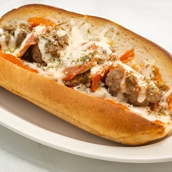A Master's Pizza Pasta & Grill meatball sub with melted cheese and pepperoni on a white plate.