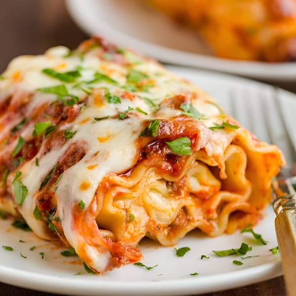 Close-up of a Master's Pizza Pasta & Grill lasagna roll-up, topped with melted cheese and parsley.